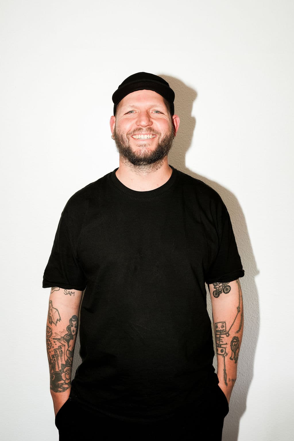Andy Woortman lächelnd vor einer weißen Studiowand