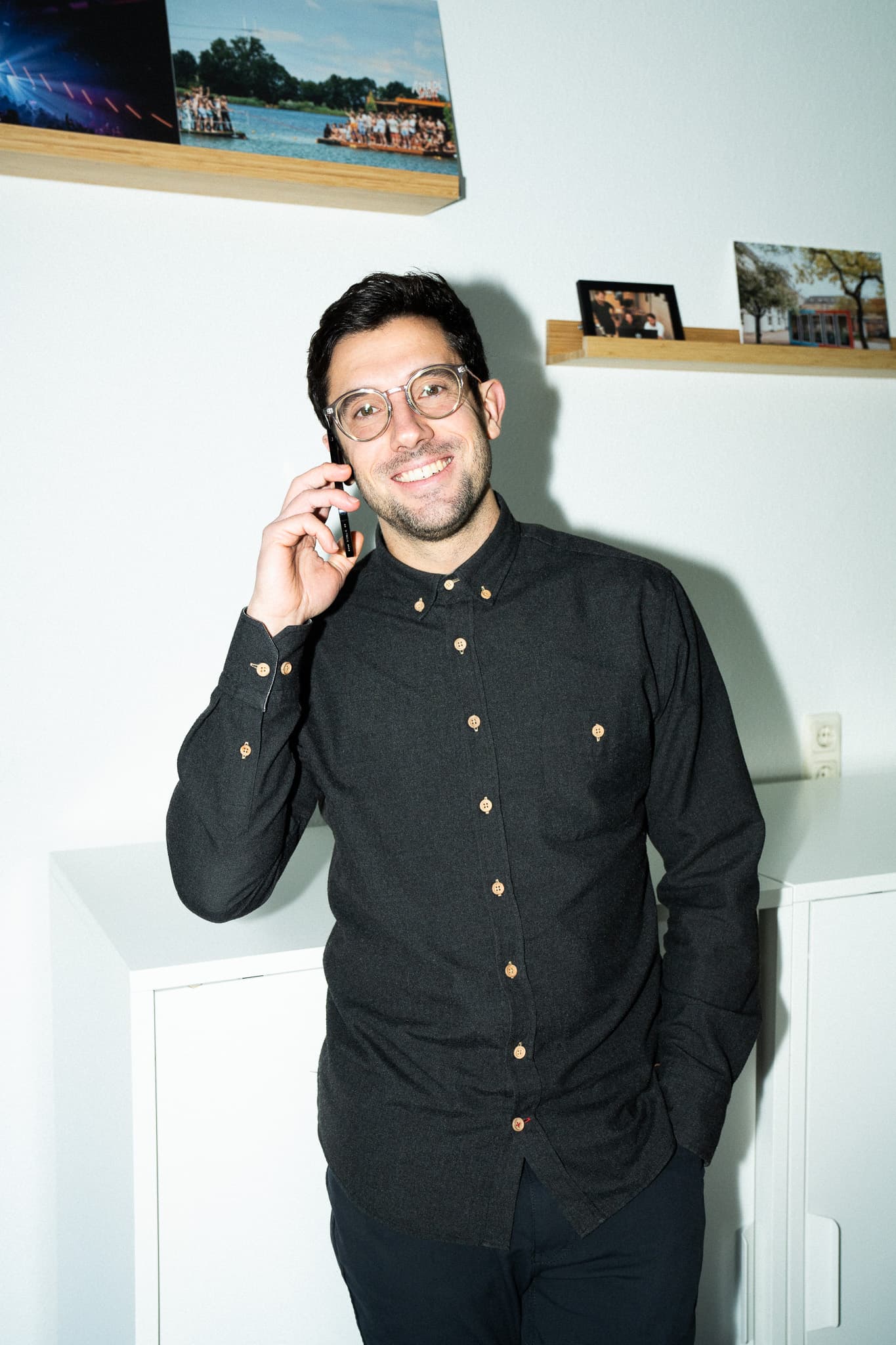 Dorian Andrzejewski lächelnd am Telefon im Studio