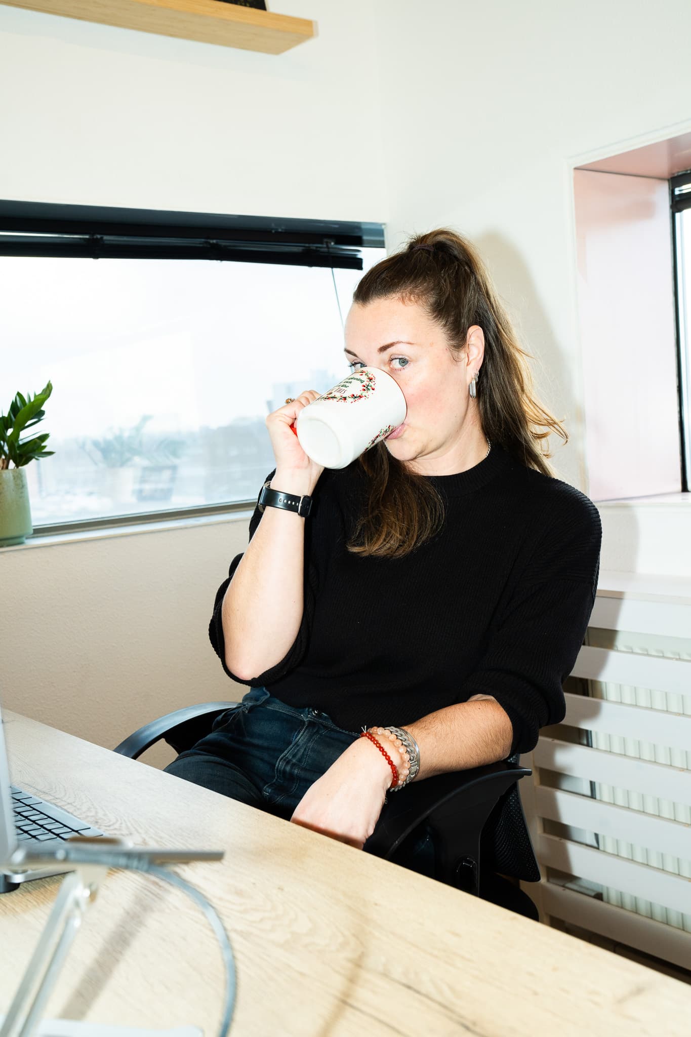 Sonja Poland trinkt an ihrem Schreibtisch im Studio aus einer Tasse