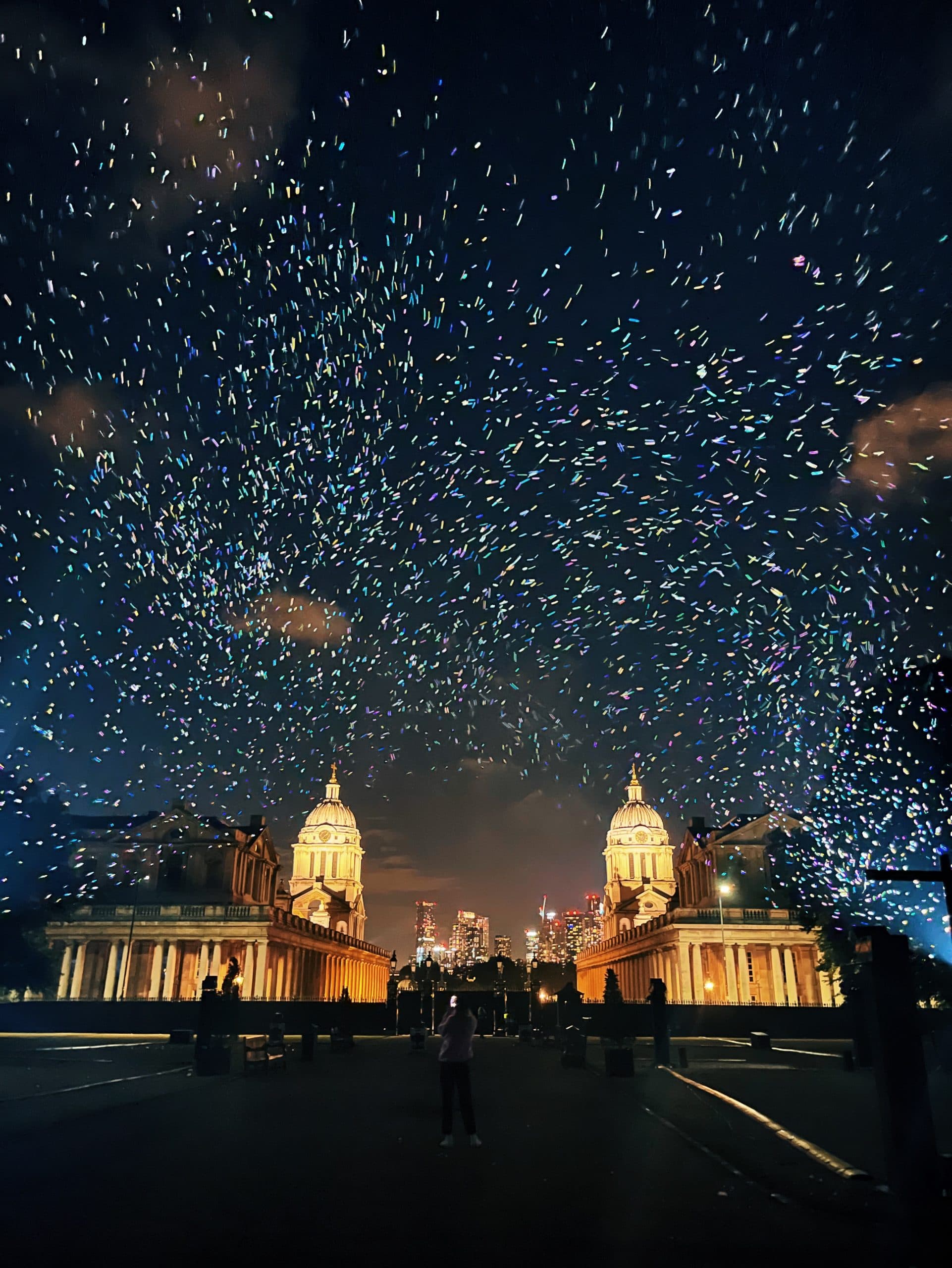 Visitors beneath thousands of biodegradable sparks drifting through the night in London