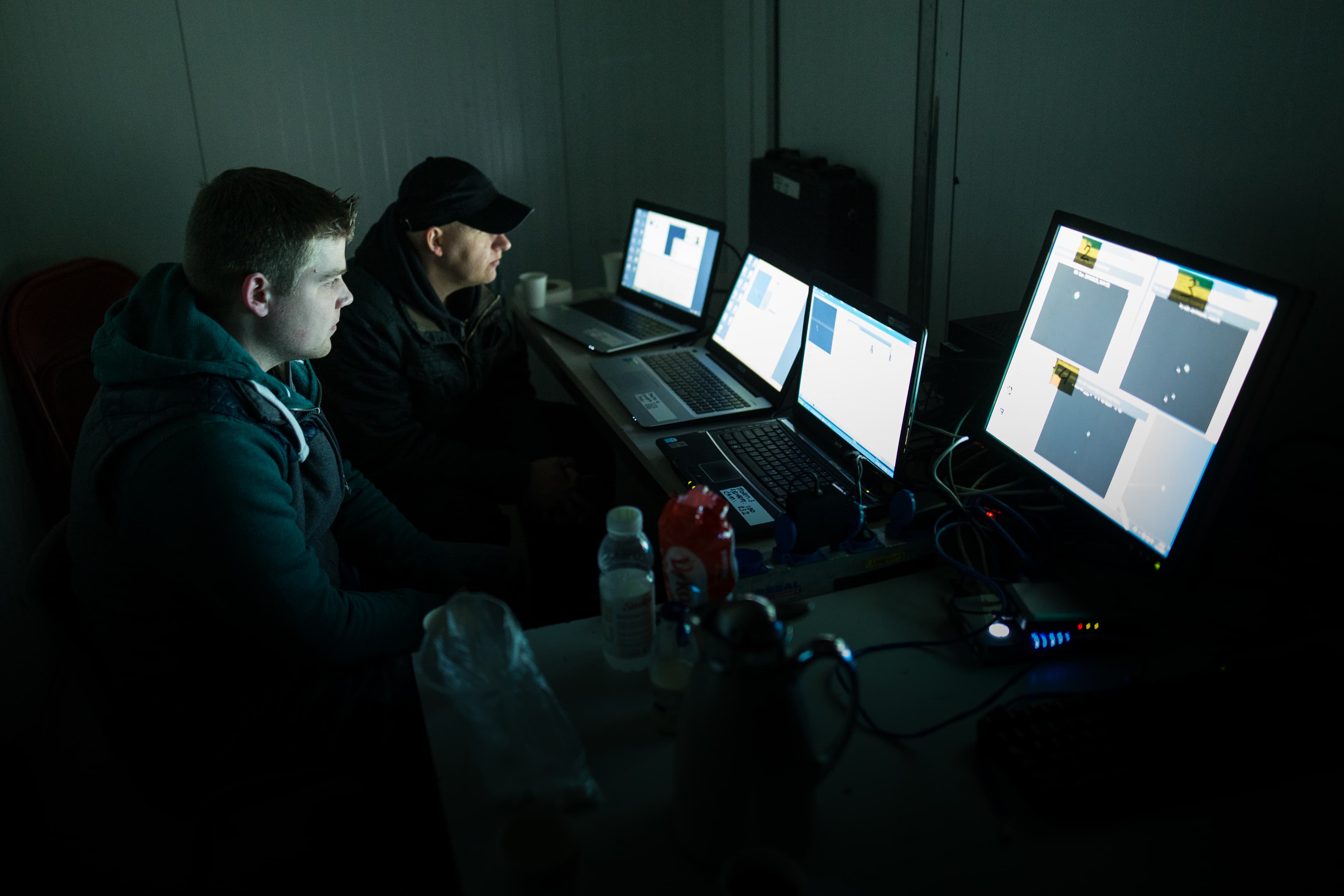 Two technicians tuning installation software on laptops beside the Windlicht structure