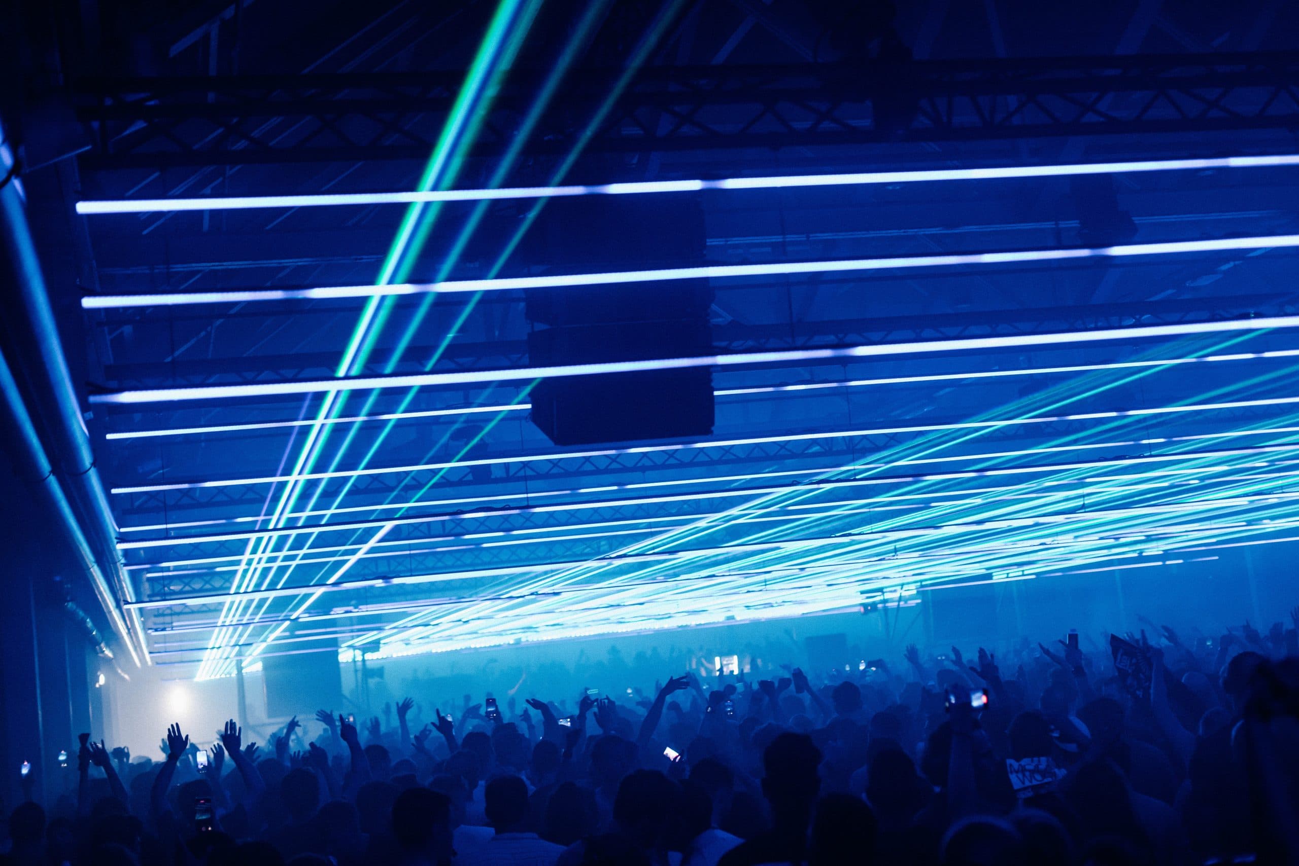 Blue and green laser lines stretching across a packed hall at Audio Obscura Festival