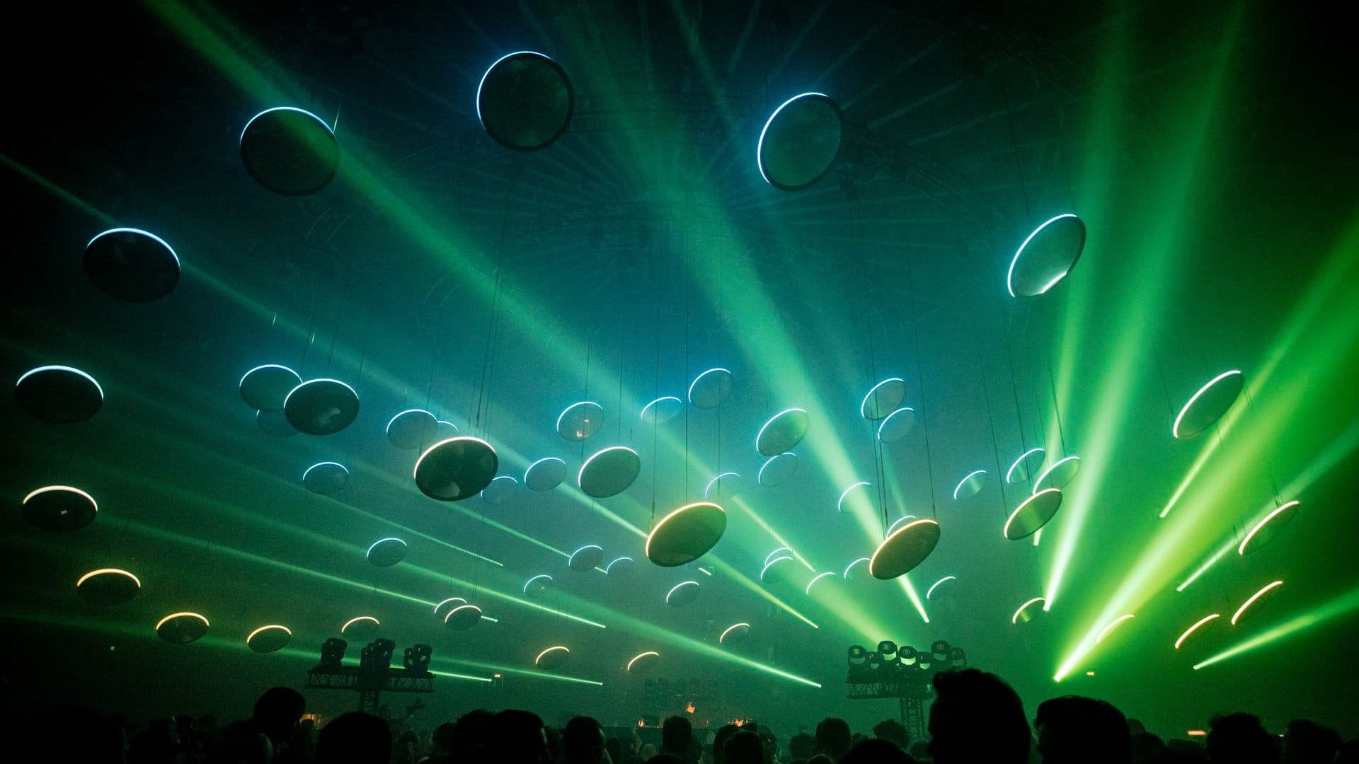 Blue and green light beams crossing a dark Audio Obscura venue during Amsterdam Dance Event