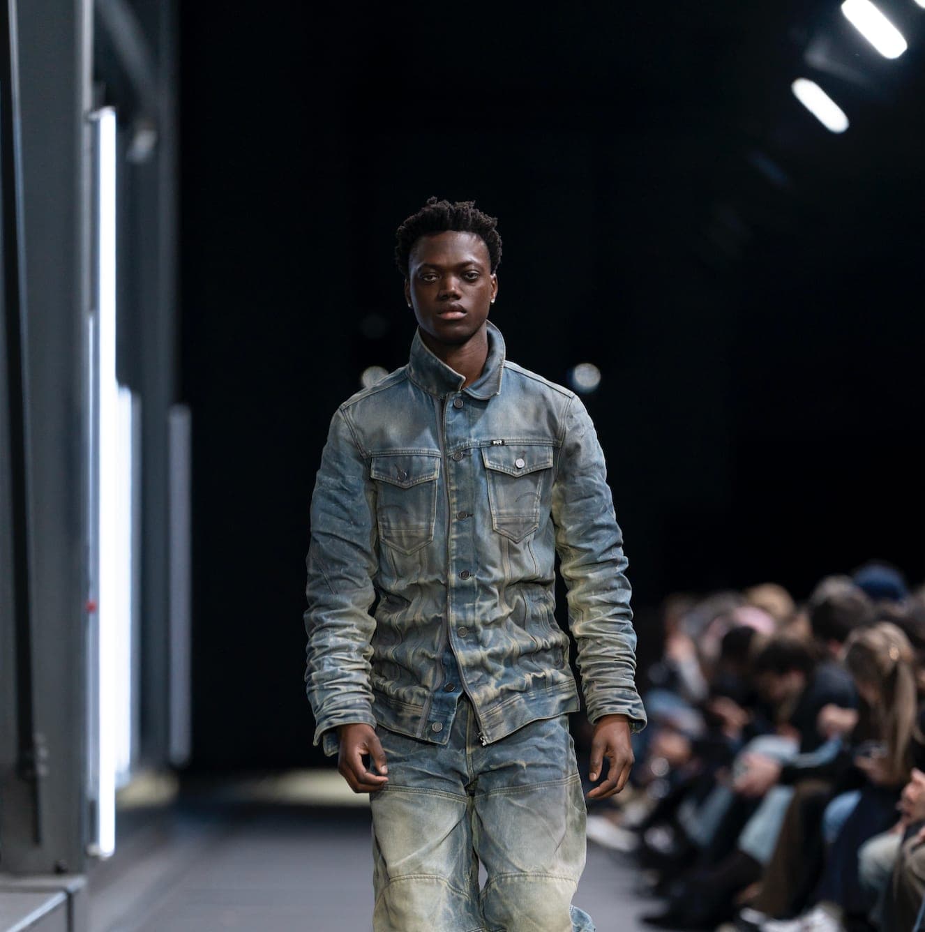 G-STAR RAW presentation framed by a dark industrial set and focused white light