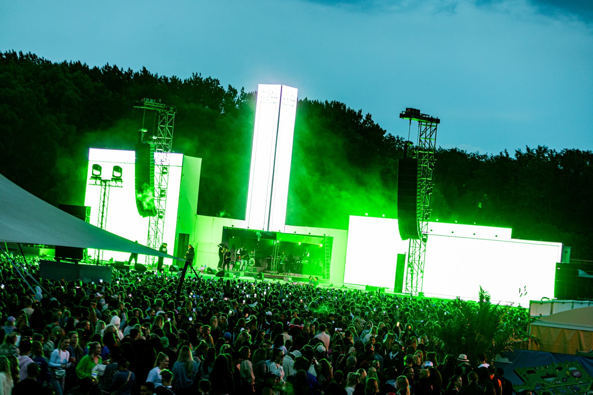 Large festival crowd facing a vivid outdoor stage at Vunzige Deuntjes Festival