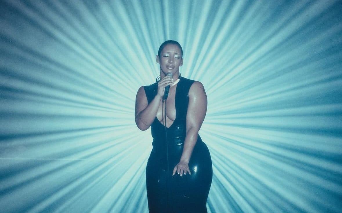 Naomi Sharon performing within a focused sculptural light design on her America tour